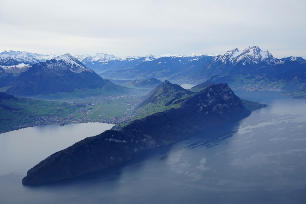 green and white mountains near body of water during daytime