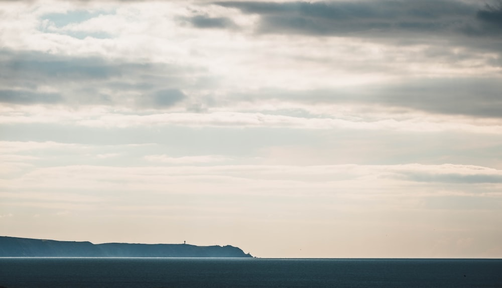 body of water under cloudy sky during daytime