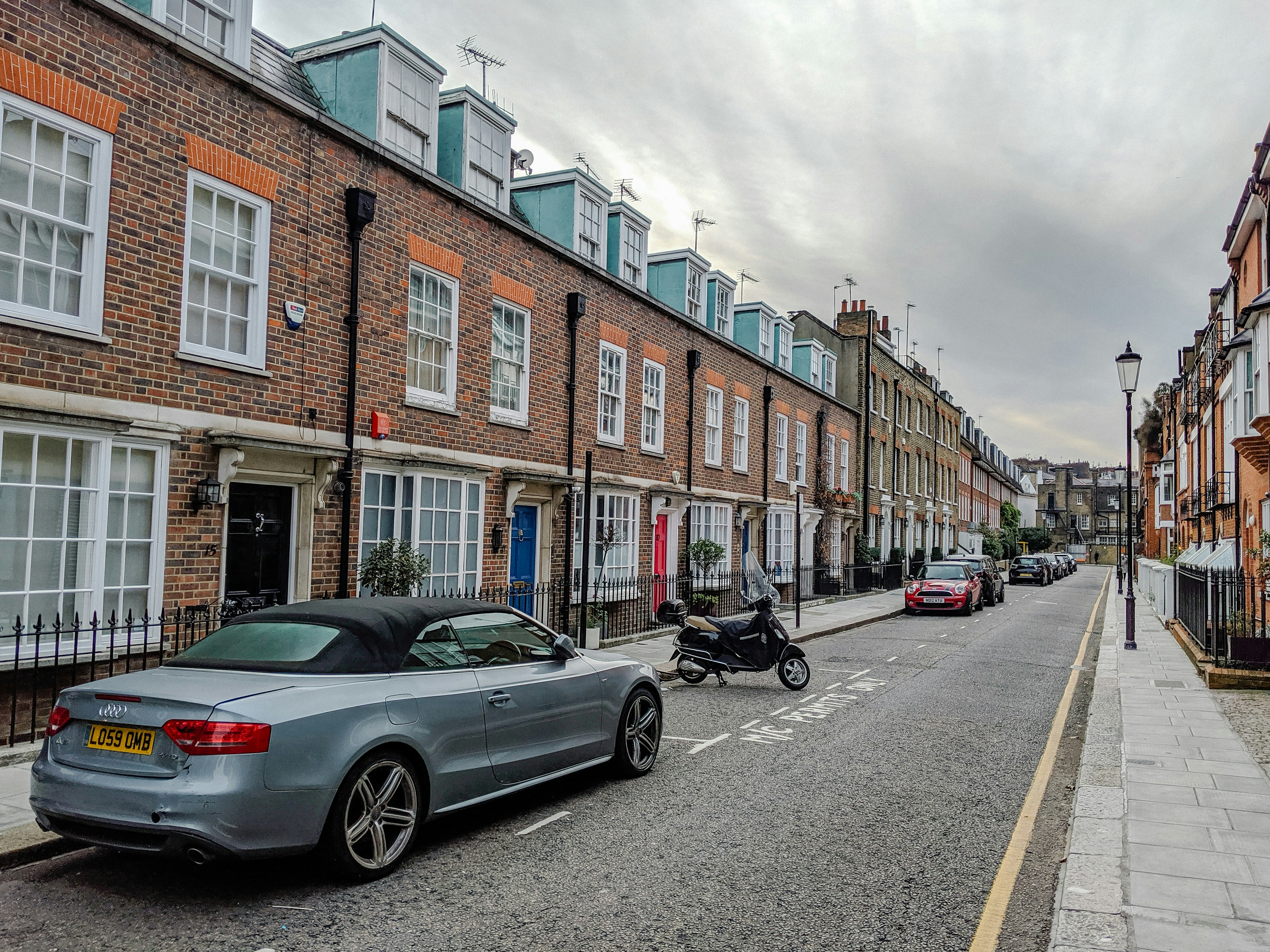 cars parked in front of brown building during daytime