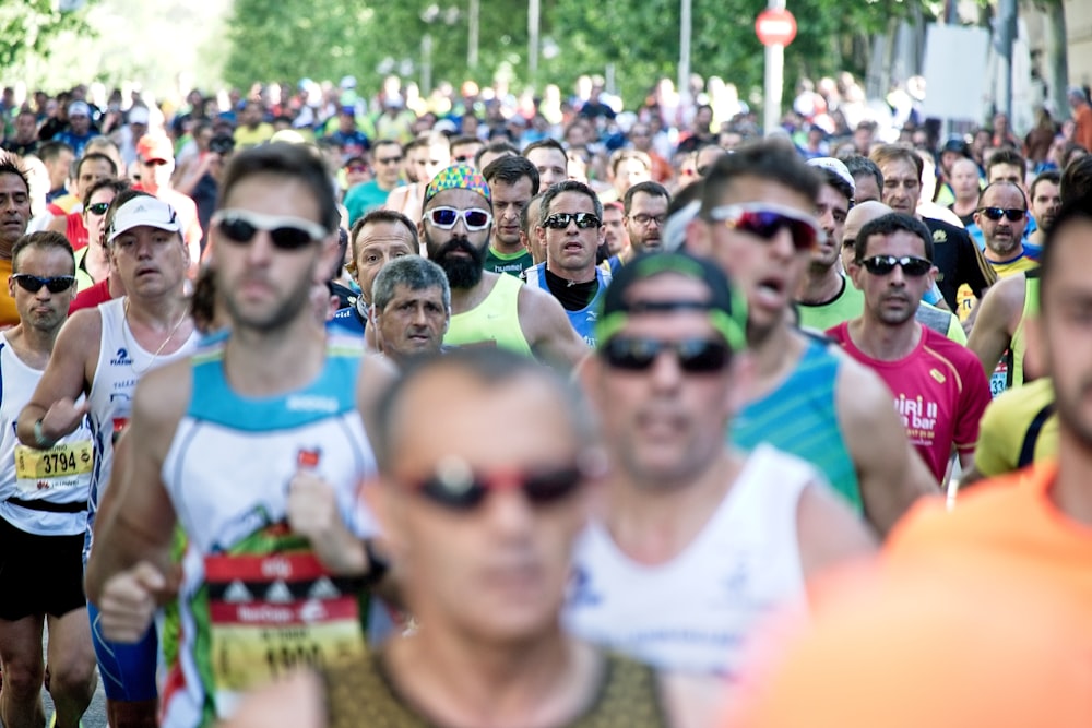 Personas con camiseta blanca sin mangas con gafas de sol durante el día