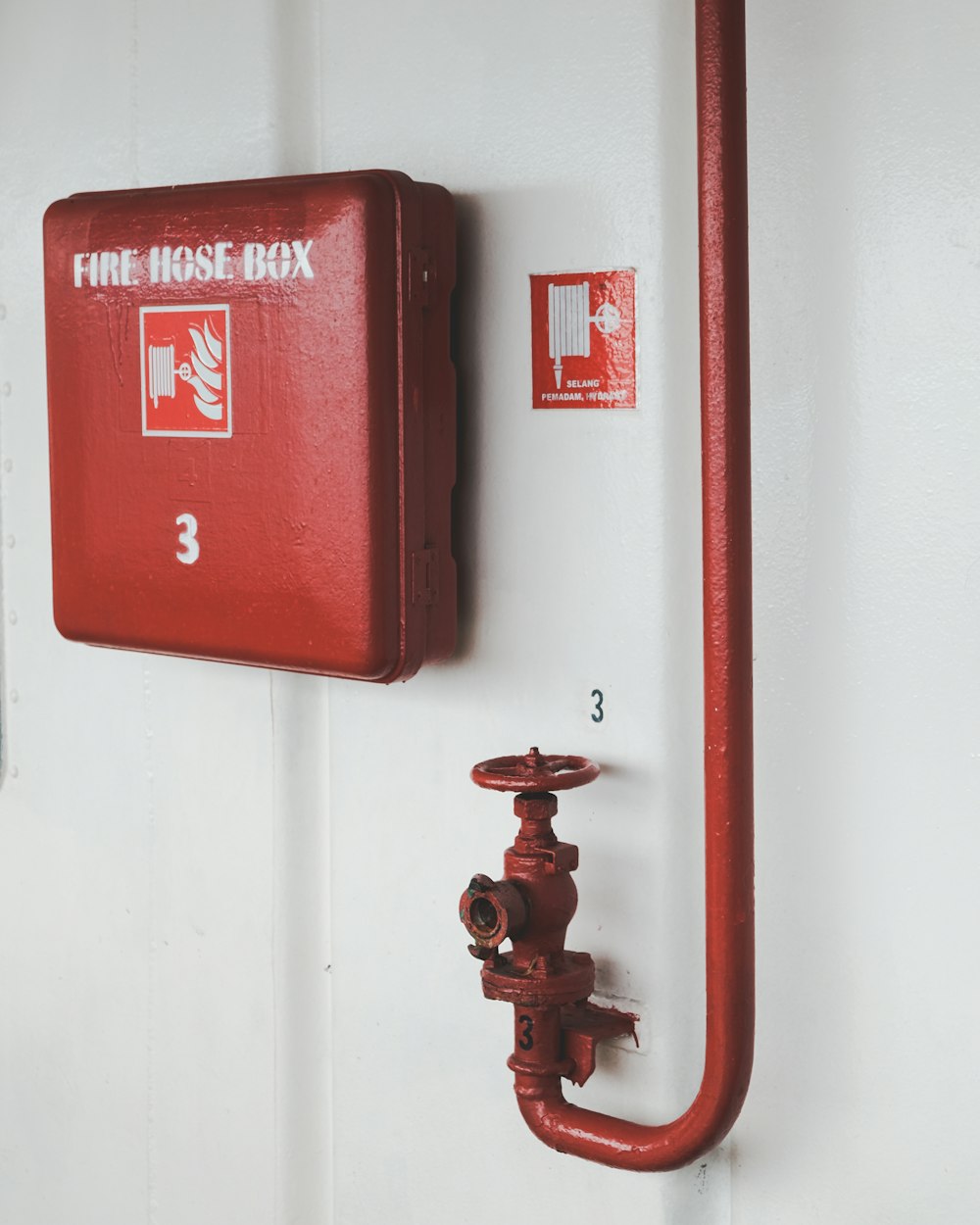 red fire extinguisher mounted on white wall