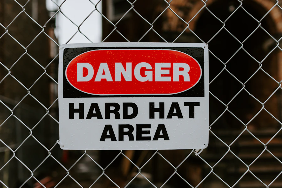 Panneau danger casque obligatoire sur clôture de chantier