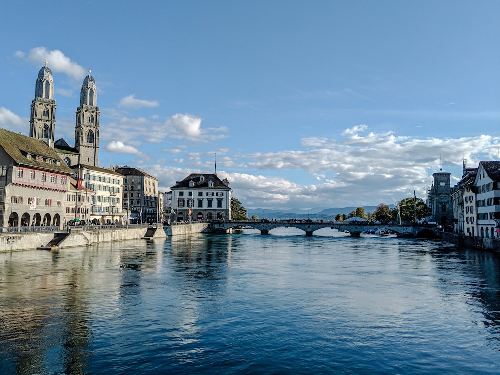 white and brown concrete building beside body of water under blue sky during daytime