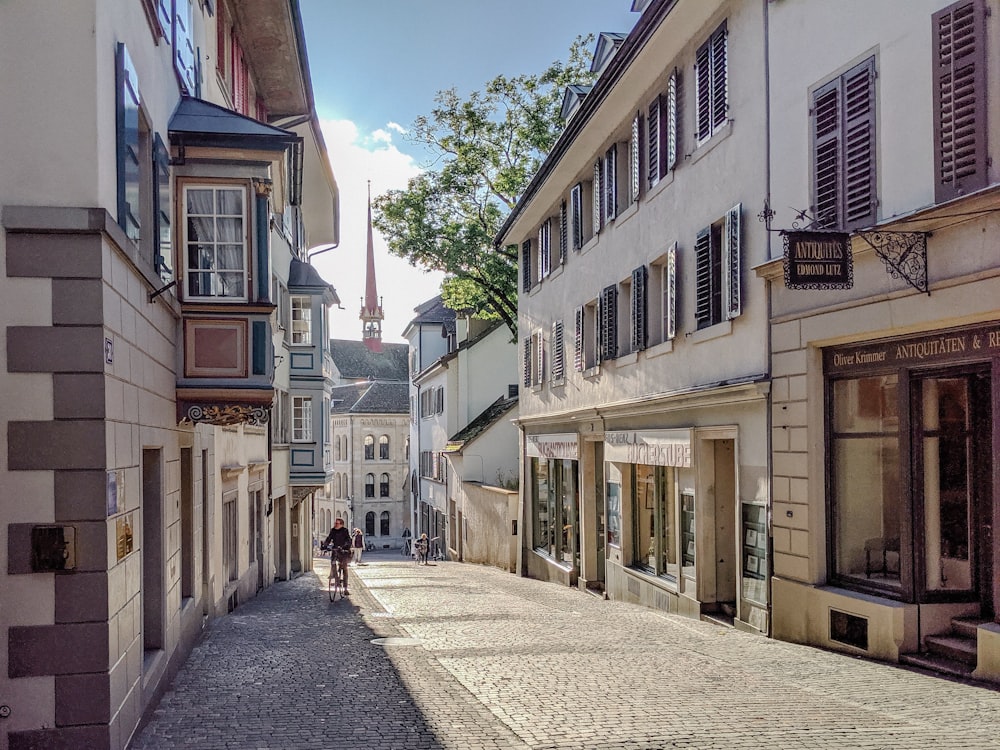 people walking on sidewalk between buildings during daytime