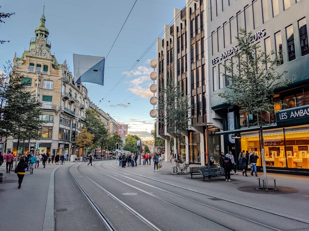 people walking on sidewalk near buildings during daytime