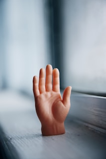 persons left hand on brown wooden table