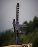 black rifle with scope on green grass field during daytime