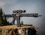 black airsoft rifle on brown grass field