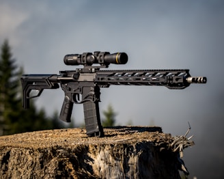 black airsoft rifle on brown grass field