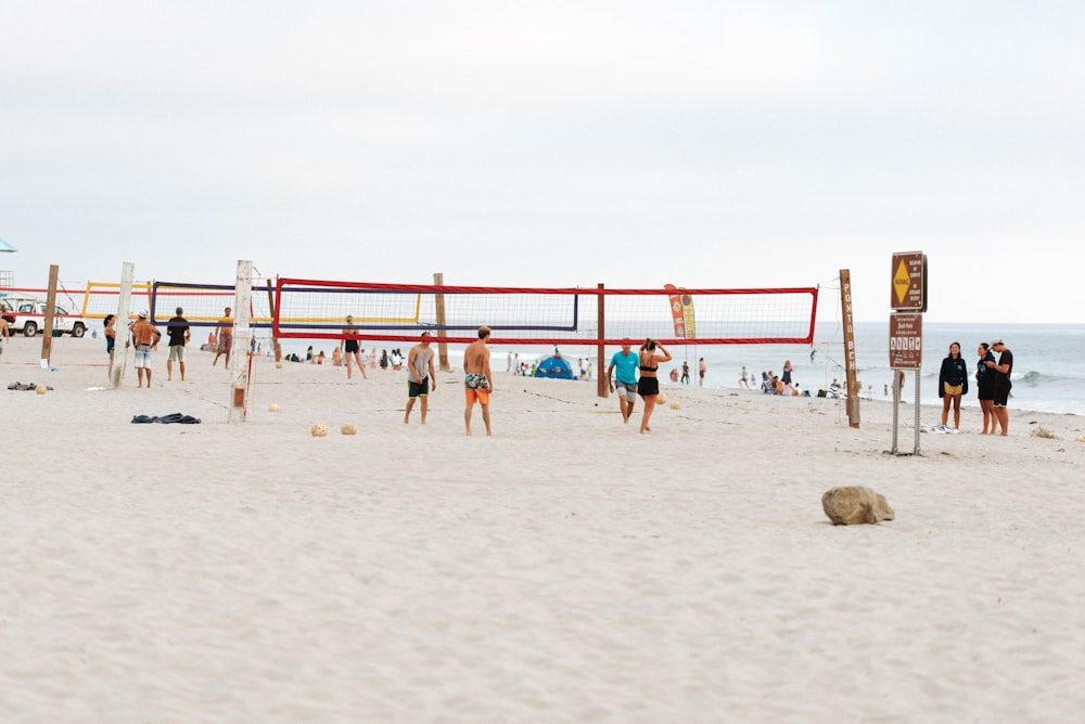 people playing beach volleyball on beach during daytime