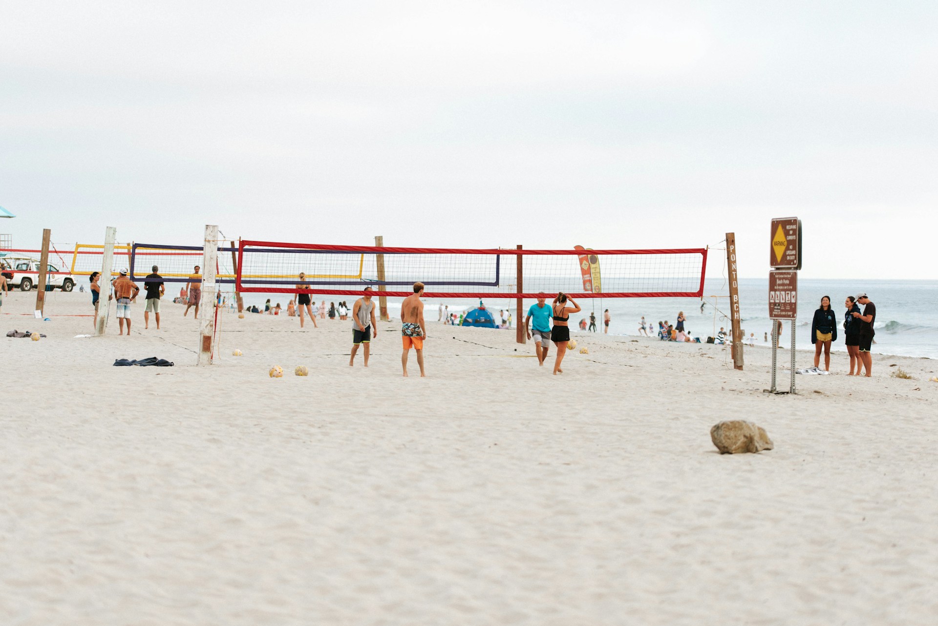 people playing beach volleyball on beach during daytime