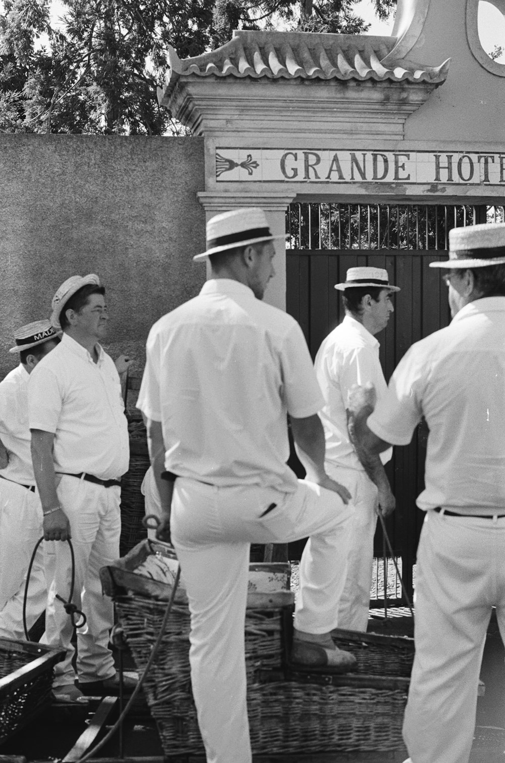 grayscale photo of 2 men in white dress shirt and black hat