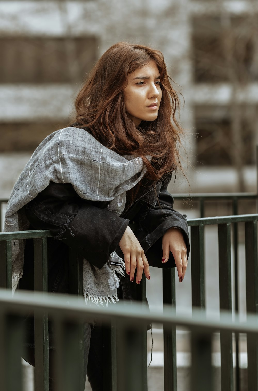 woman in white and black plaid long sleeve shirt and black pants sitting on gray wooden