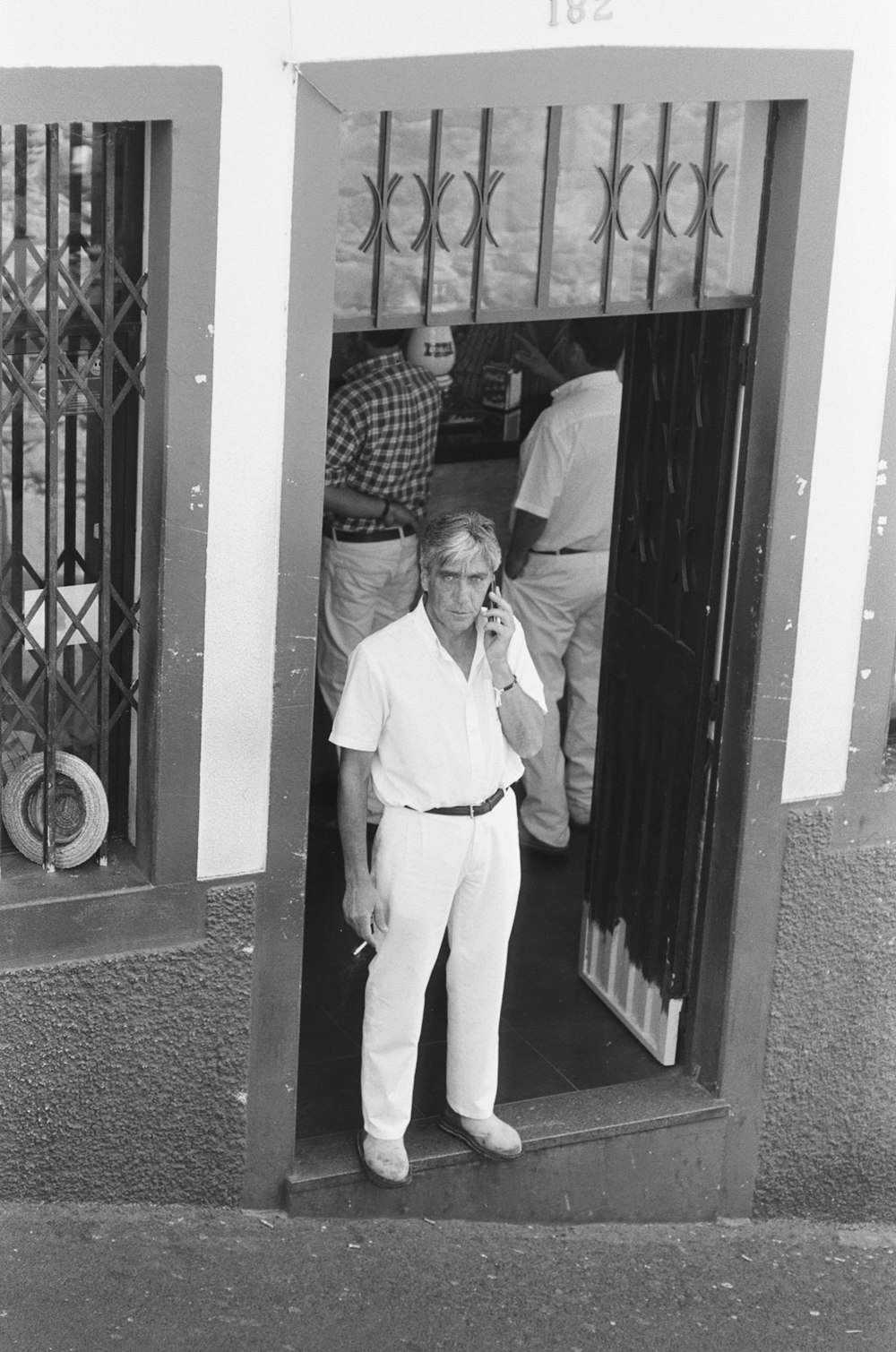 man in white dress shirt and pants standing beside man in white dress shirt