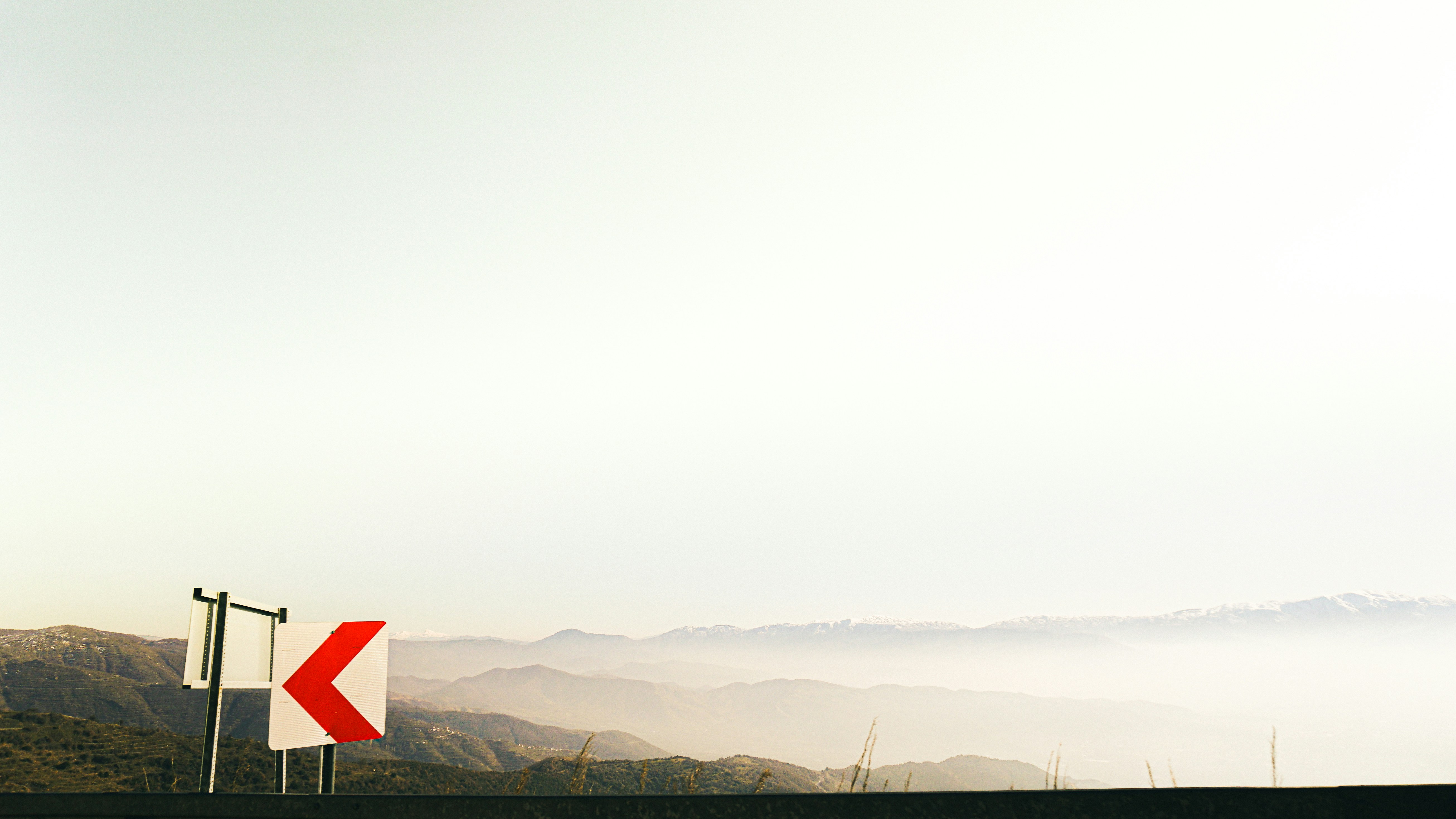 a red and white sign sitting on the side of a road