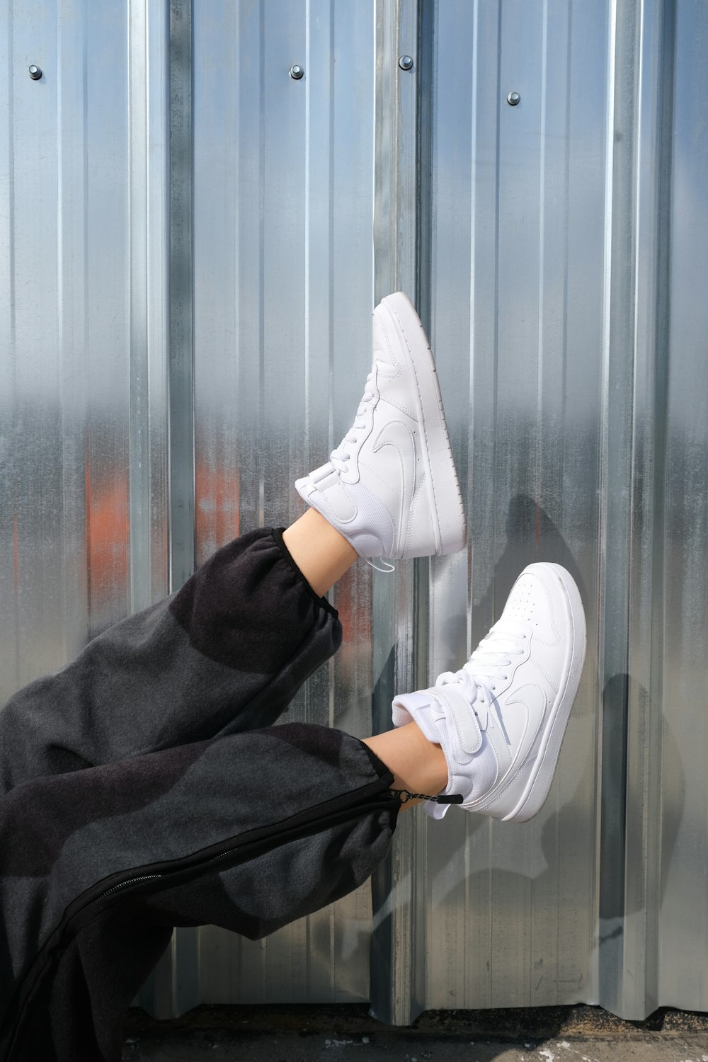 person wearing white nike sneakers