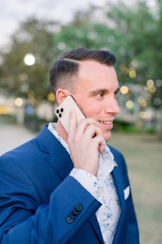 woman in blue blazer holding white smartphone