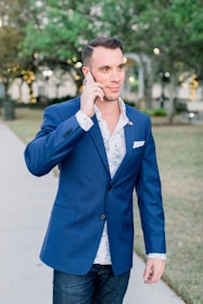 man in blue blazer holding phone