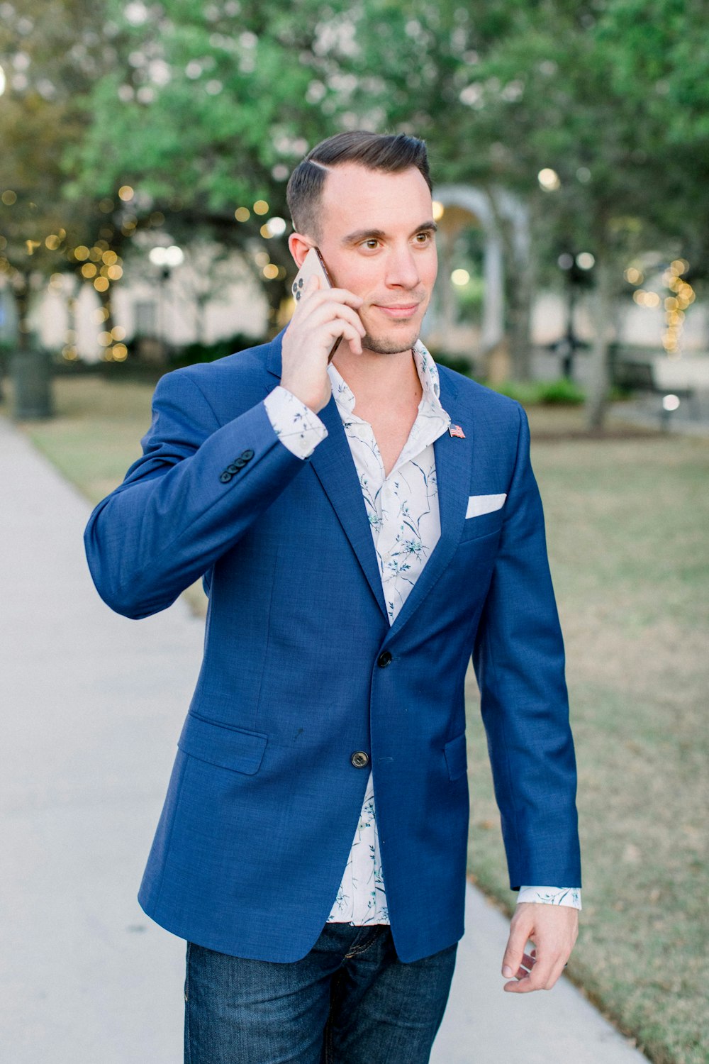 man in blue blazer holding phone