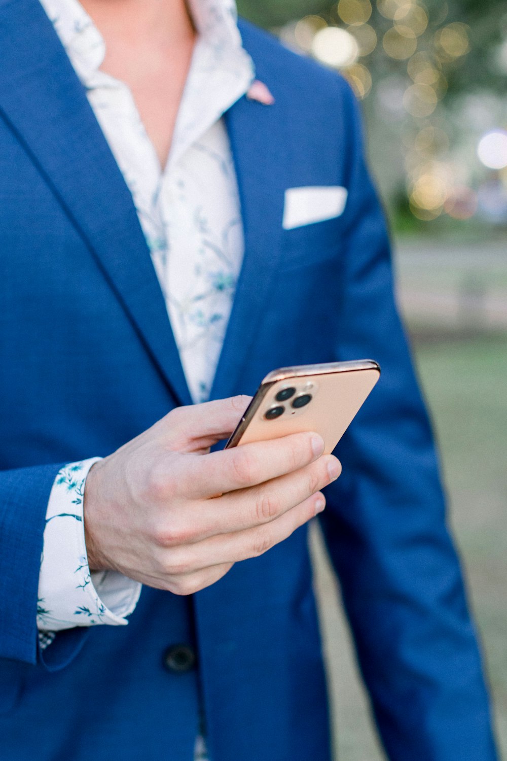 man in blue suit jacket holding silver iphone 6
