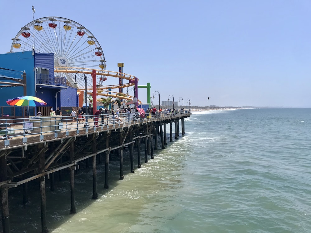 a pier with a ferris wheel and people on it