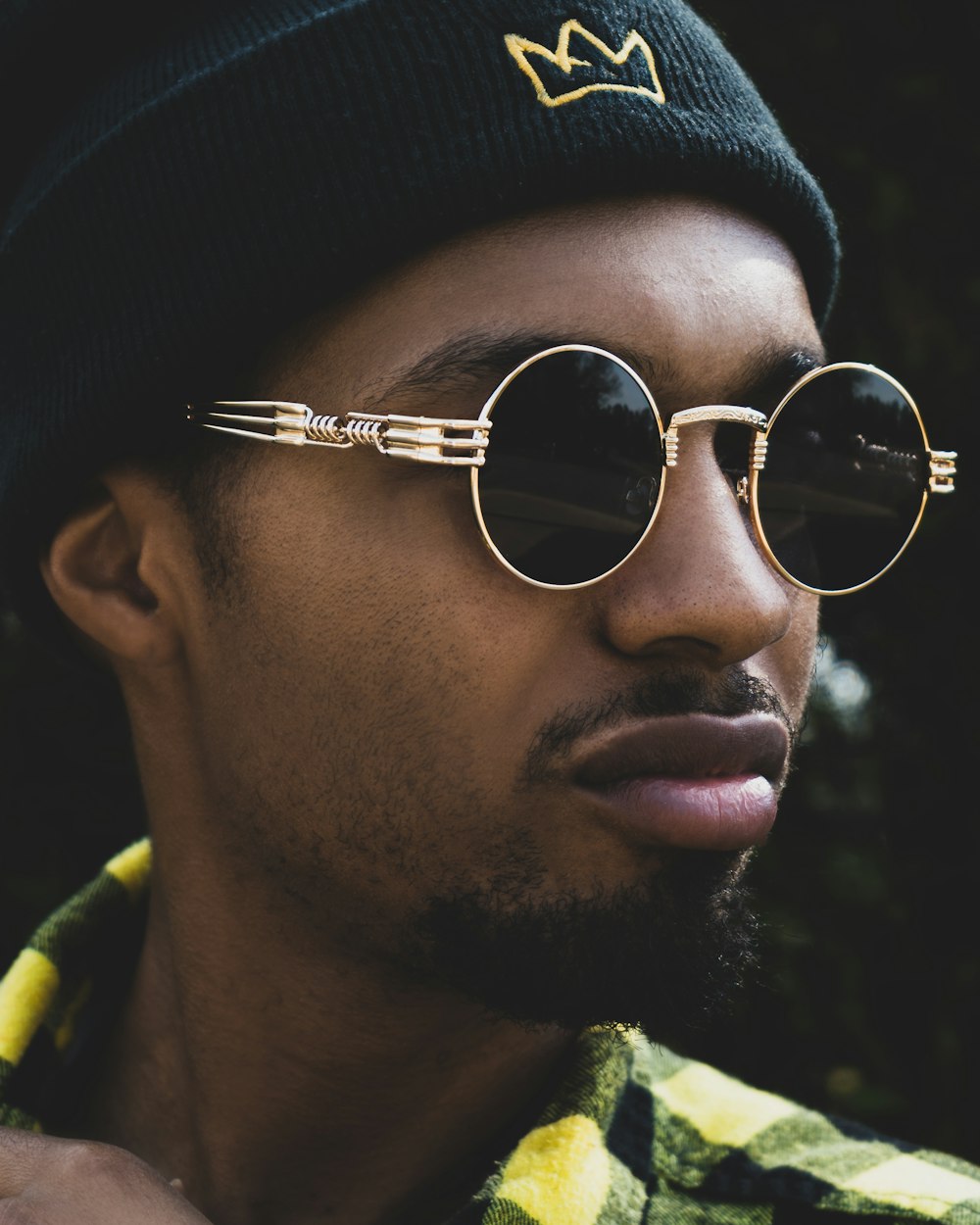 man in black knit hat and silver framed aviator sunglasses
