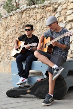 man in brown and black button up shirt playing brown acoustic guitar