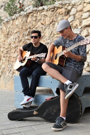man in brown and black button up shirt playing brown acoustic guitar
