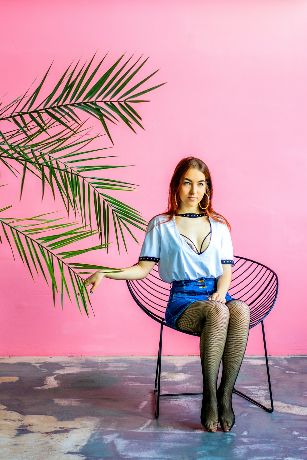 woman in blue denim shorts sitting on black metal chair