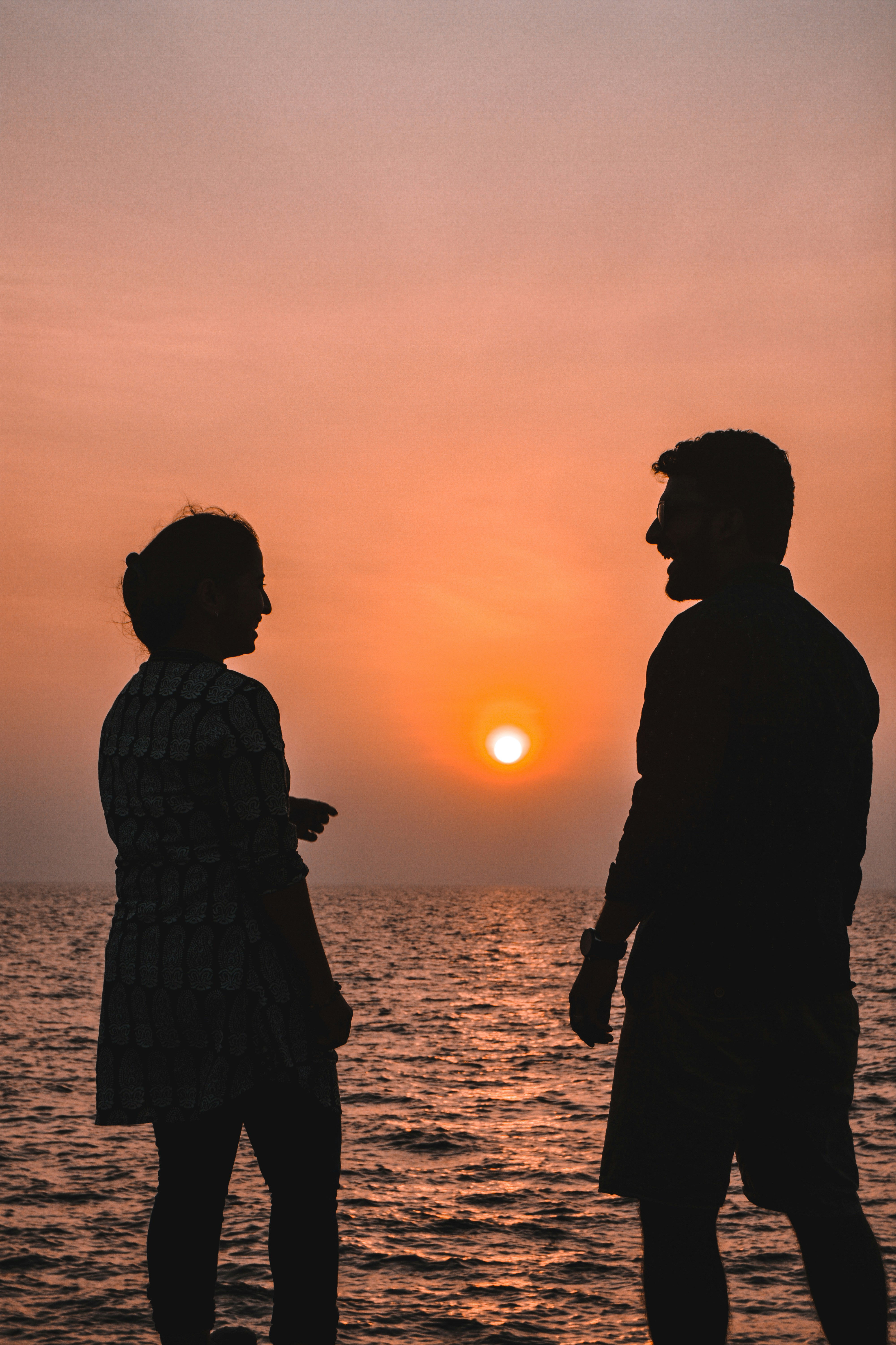 silhouette of man standing on beach during sunset