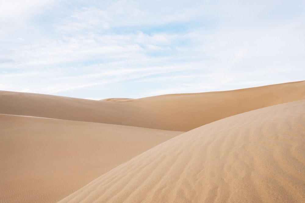 brauner Sand unter weißen Wolken tagsüber