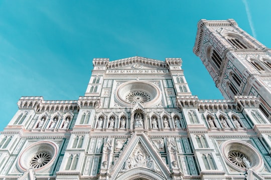 white concrete building under blue sky during daytime in Cathedral of Santa Maria del Fiore Italy