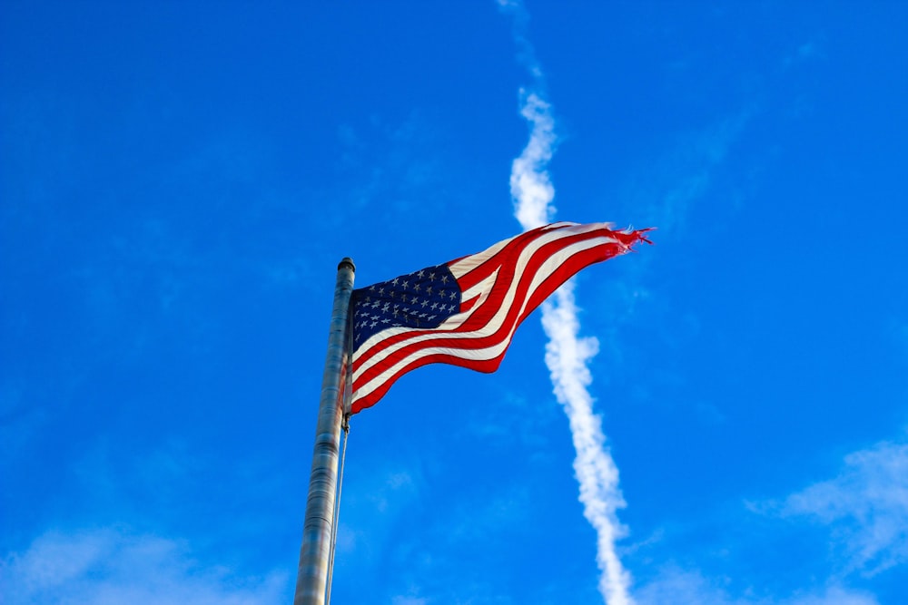 us a flag on pole under blue sky during daytime