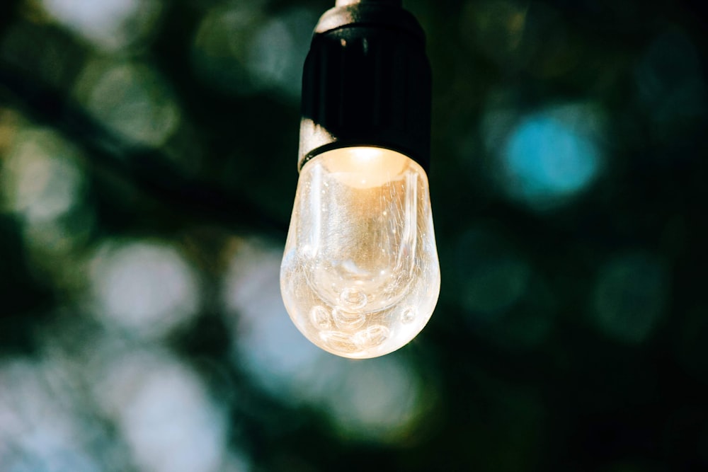 clear glass light bulb turned on in tilt shift lens