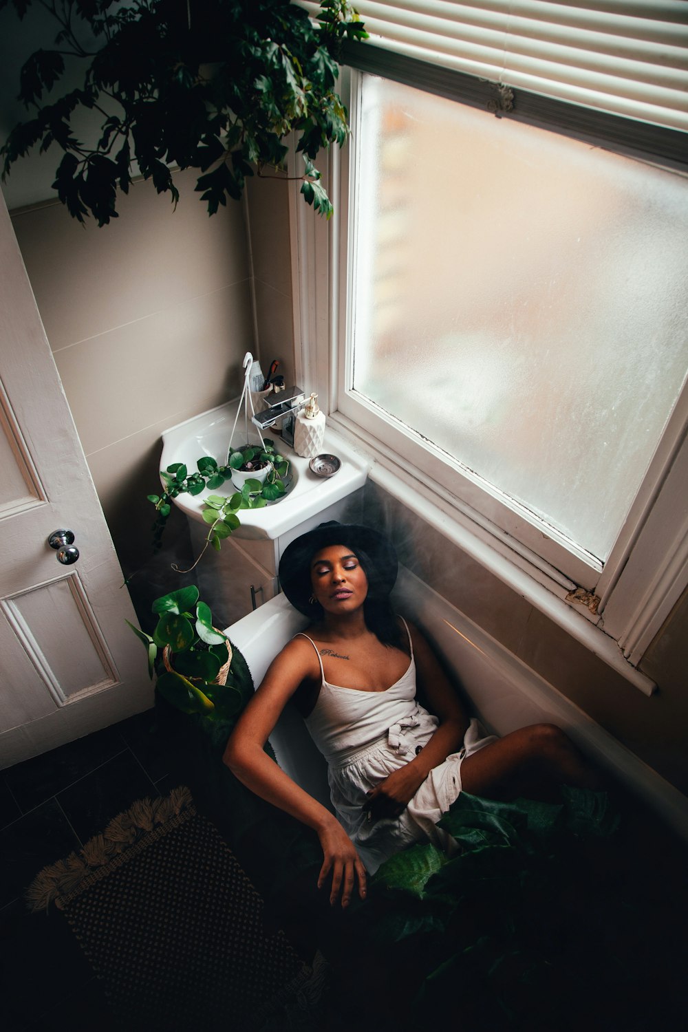a woman sitting in a bathtub next to a window