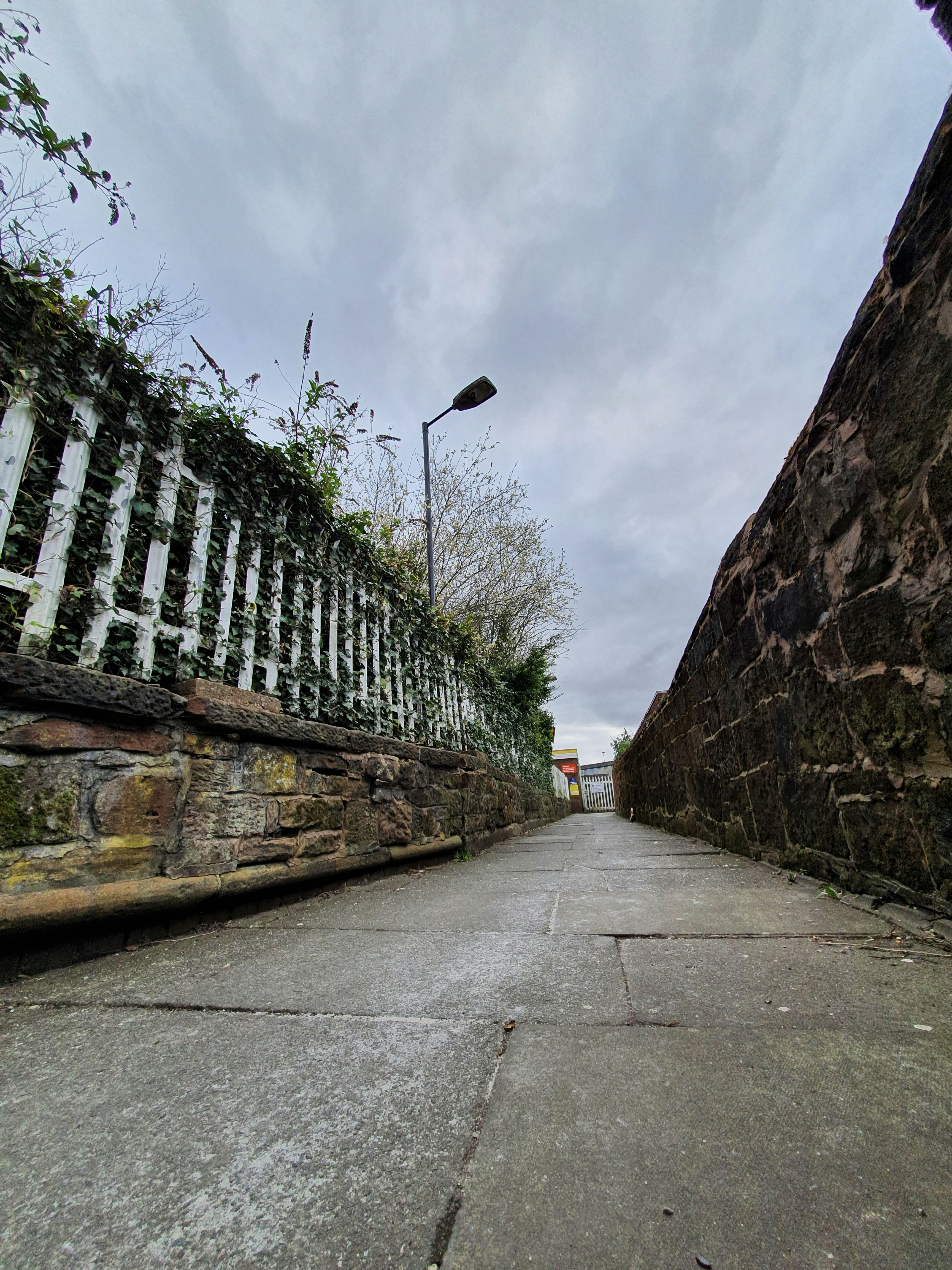 An empty path leading to a train station on an overcast day in Liverpool