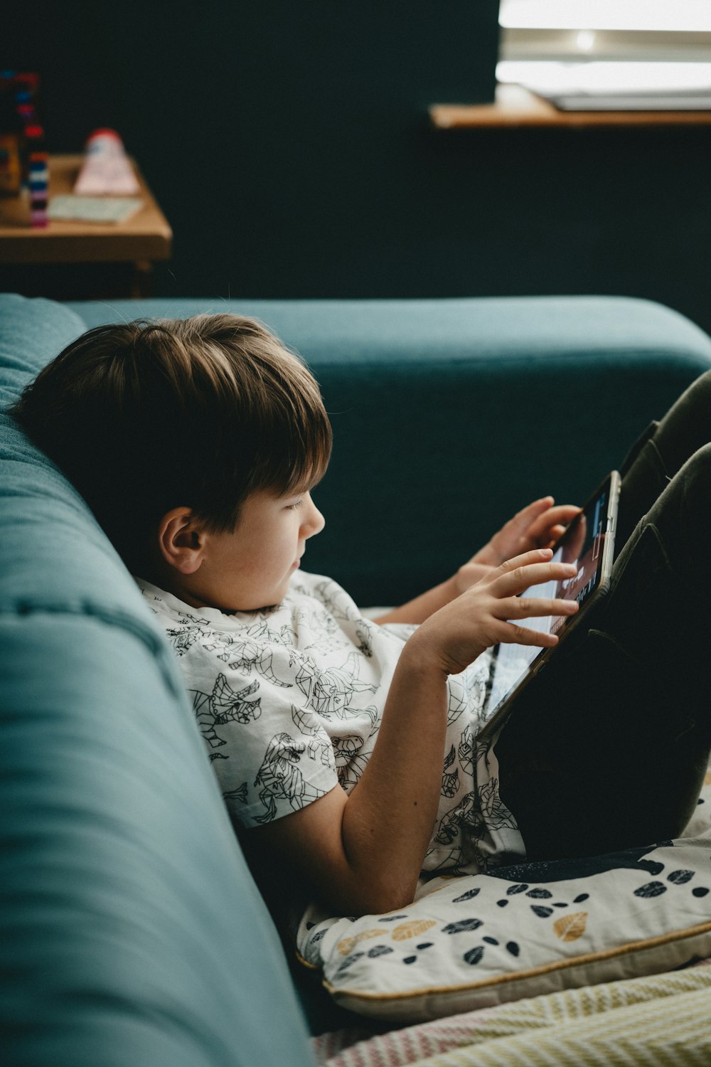 boy in white shirt lying on blue couch