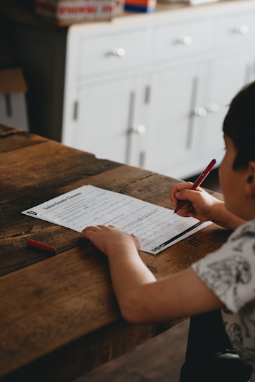A child happily working on a colorful worksheet at a tidy desk.