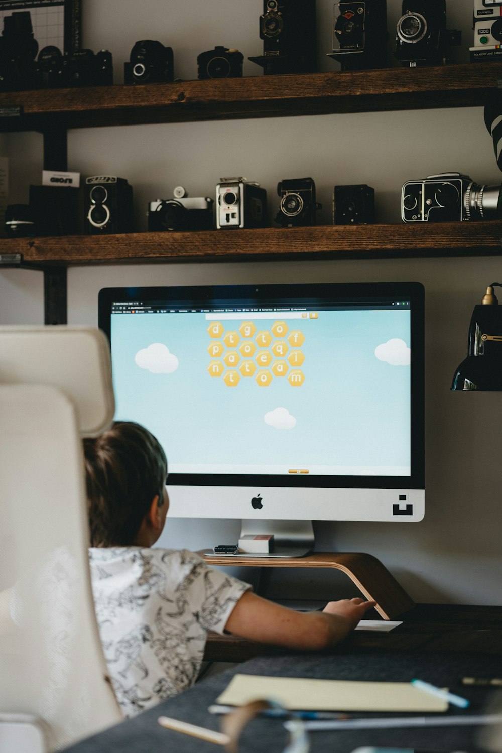 woman in white shirt using imac