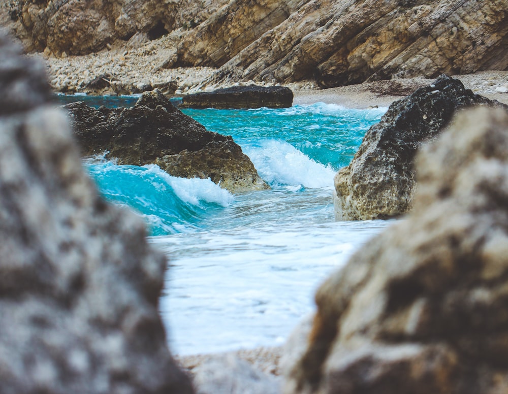 water waves hitting rocky shore during daytime