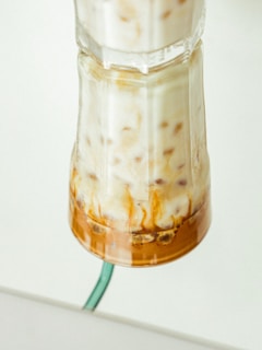Close-up of a protein shake in a glass with a swirl of creamy texture.