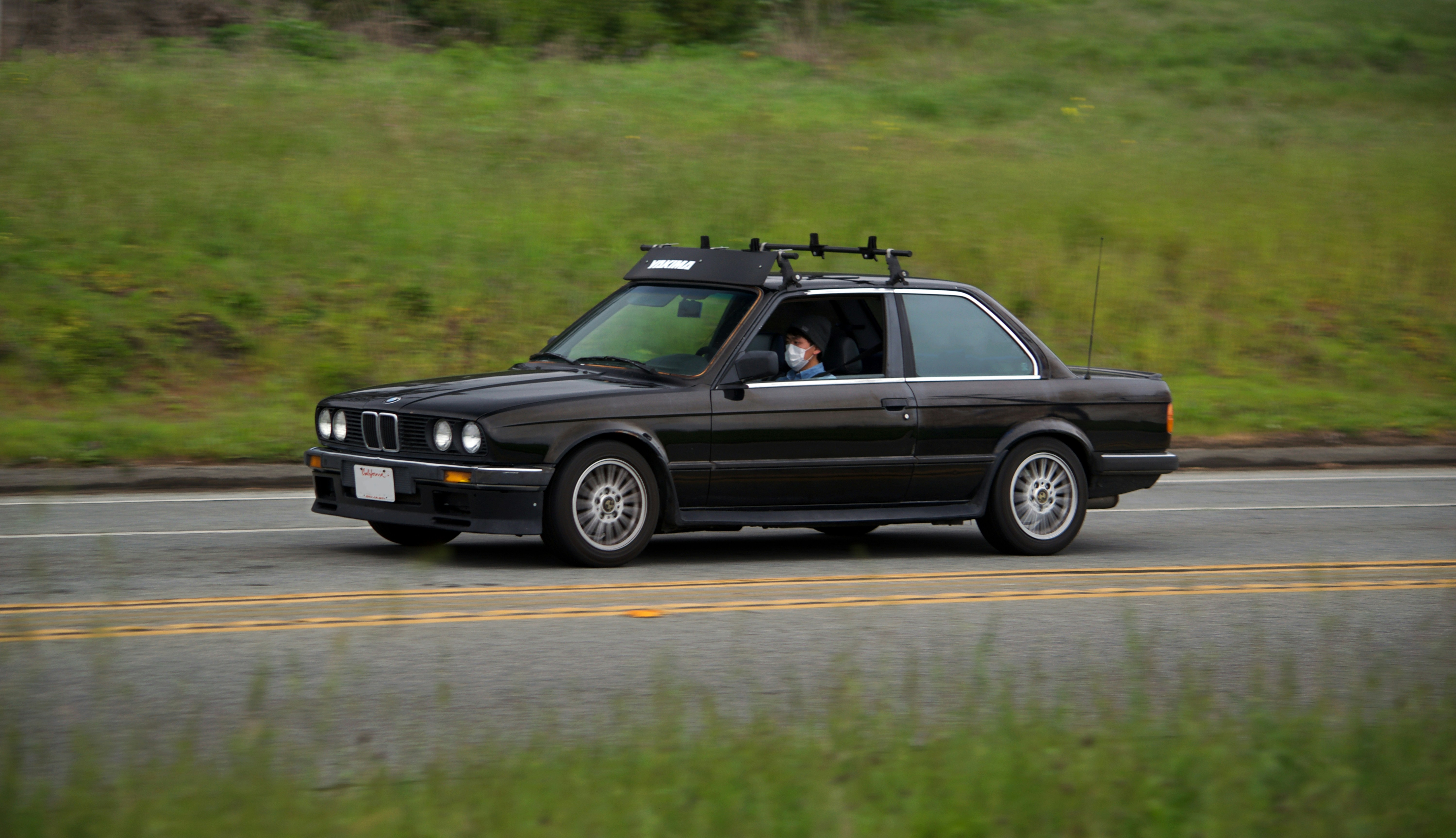 A black BMW driving on the highway.