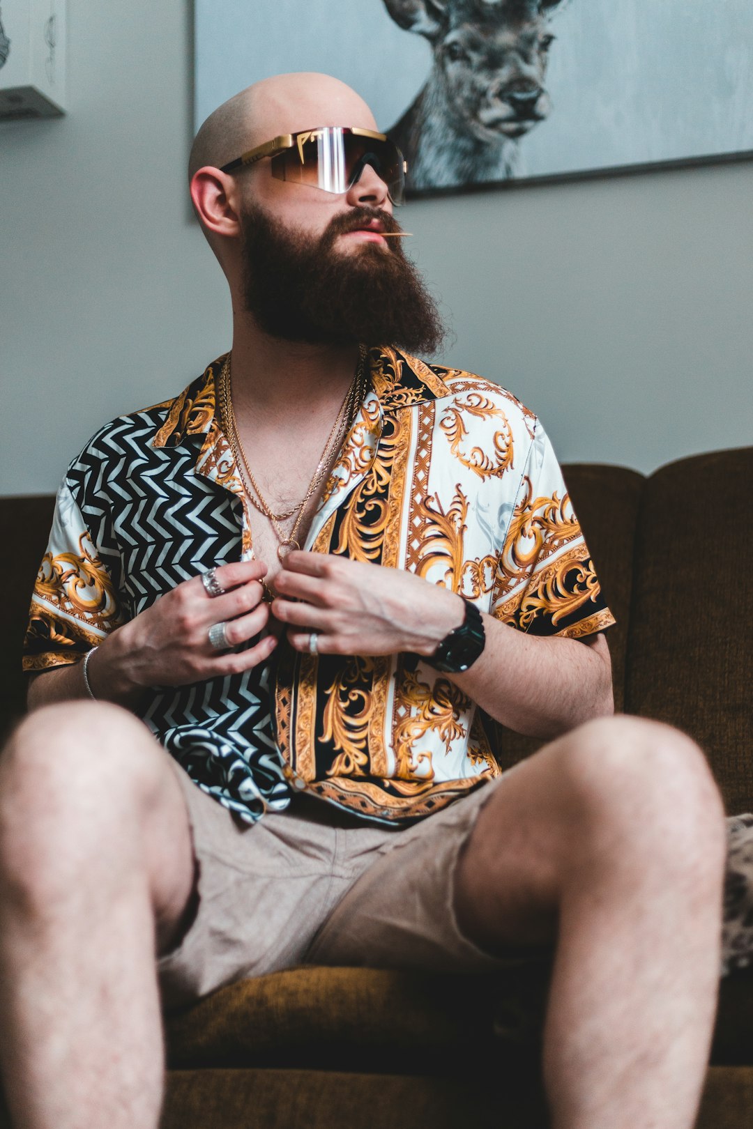 woman in brown and white floral shirt sitting on brown couch