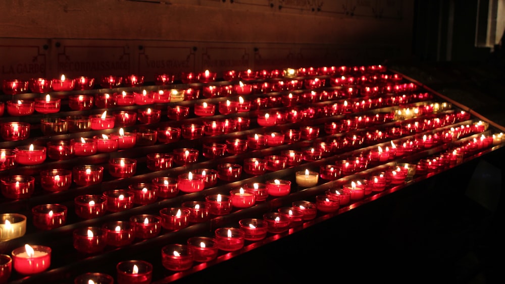 rote Kerzen auf braunem Holzgestell