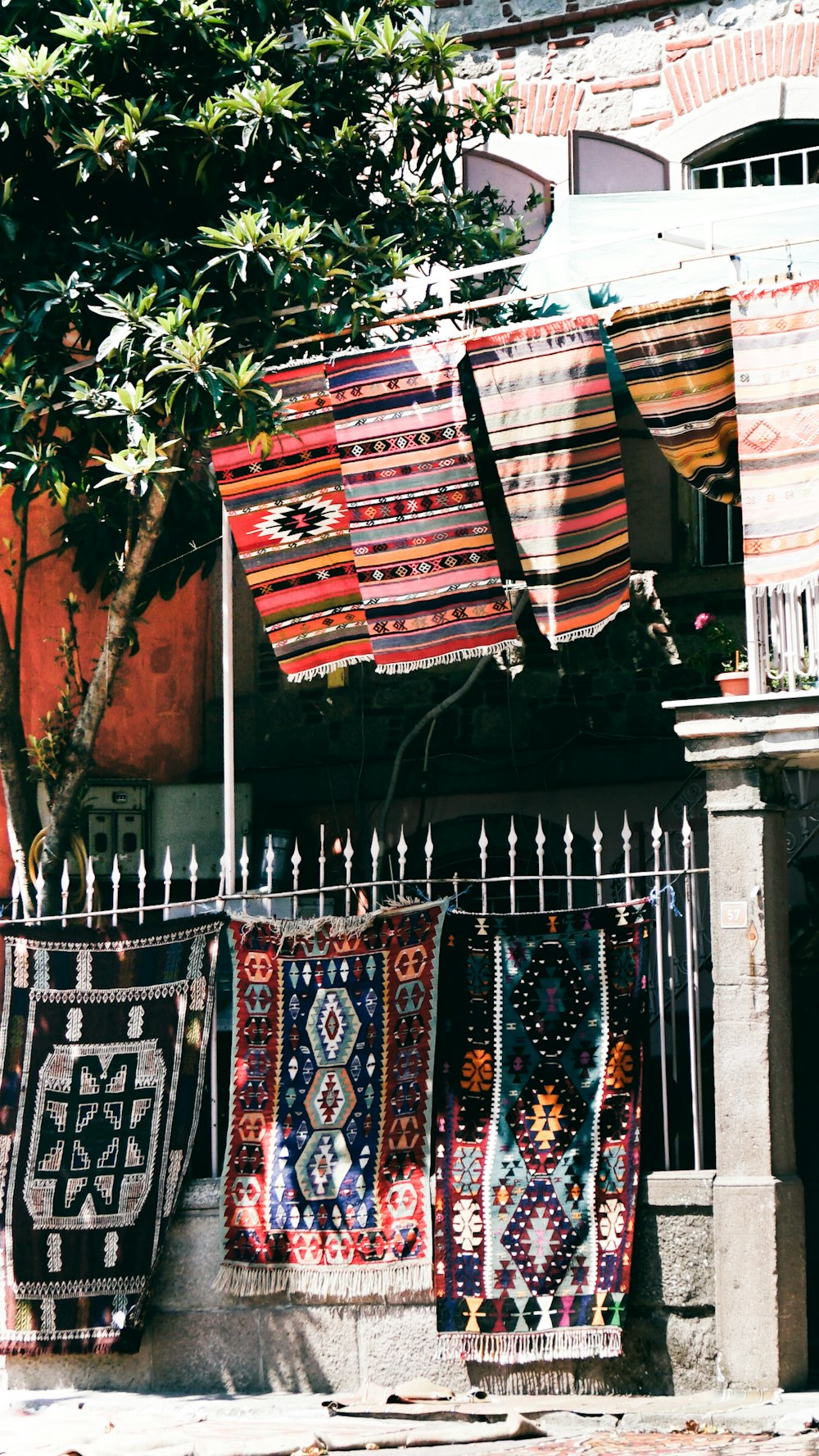 azul vermelho e branco tribal impressão têxtil na cerca de metal branco
