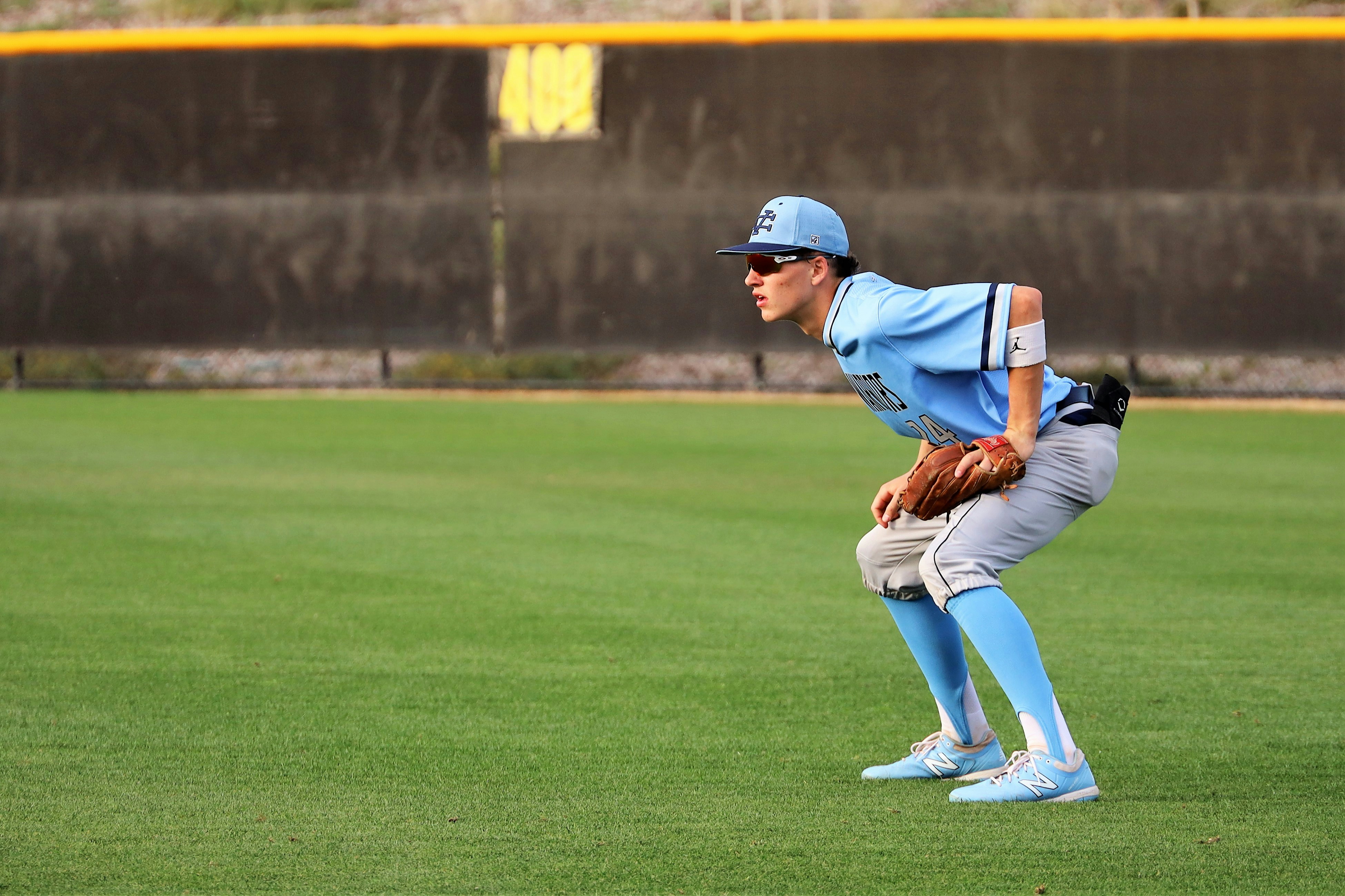 man in blue baseball jersey shirt and brown pants