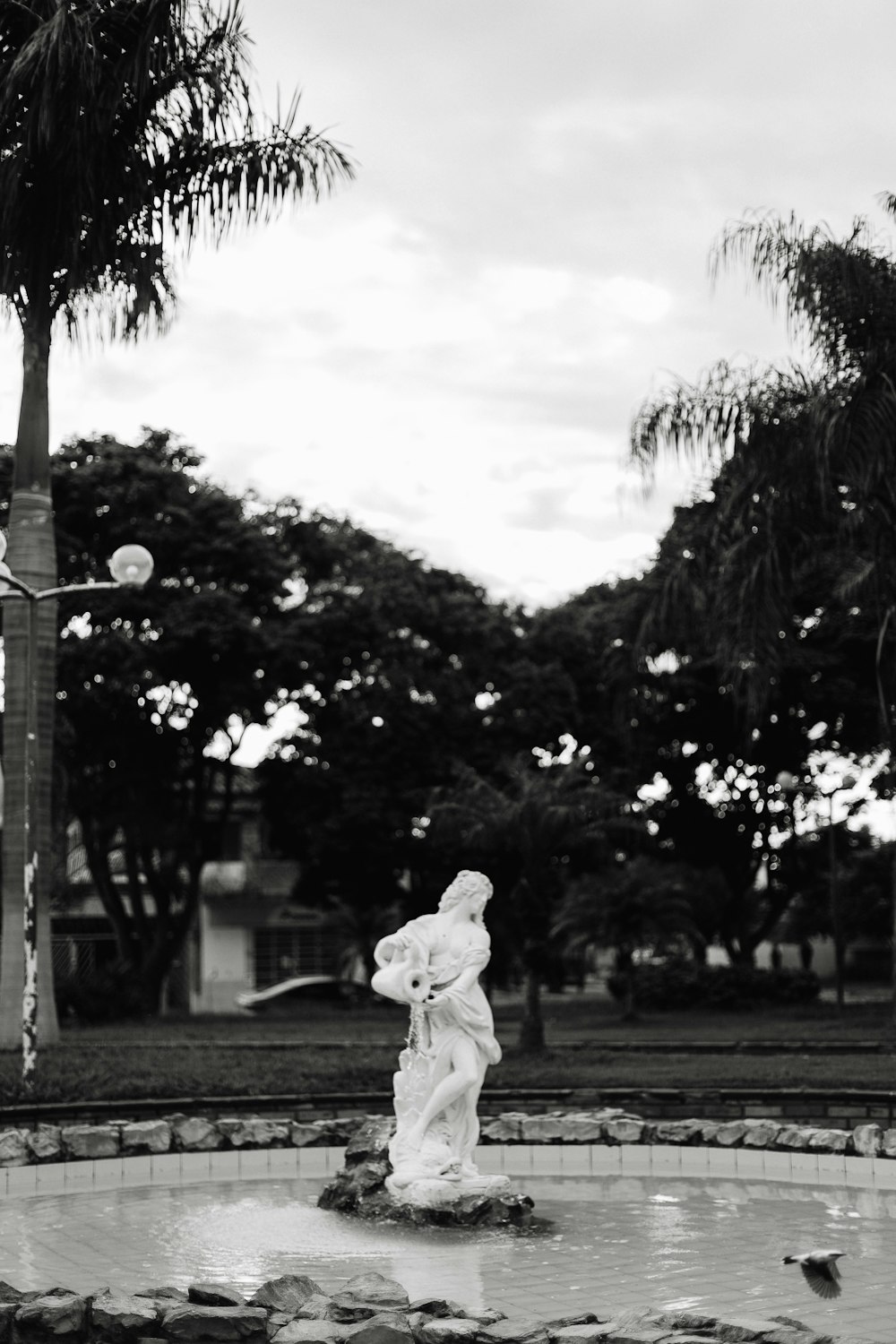 grayscale photo of woman in white dress standing on road