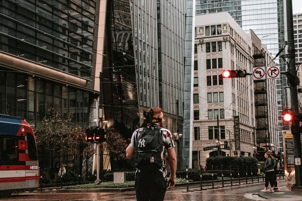 man in black jacket standing on sidewalk during daytime