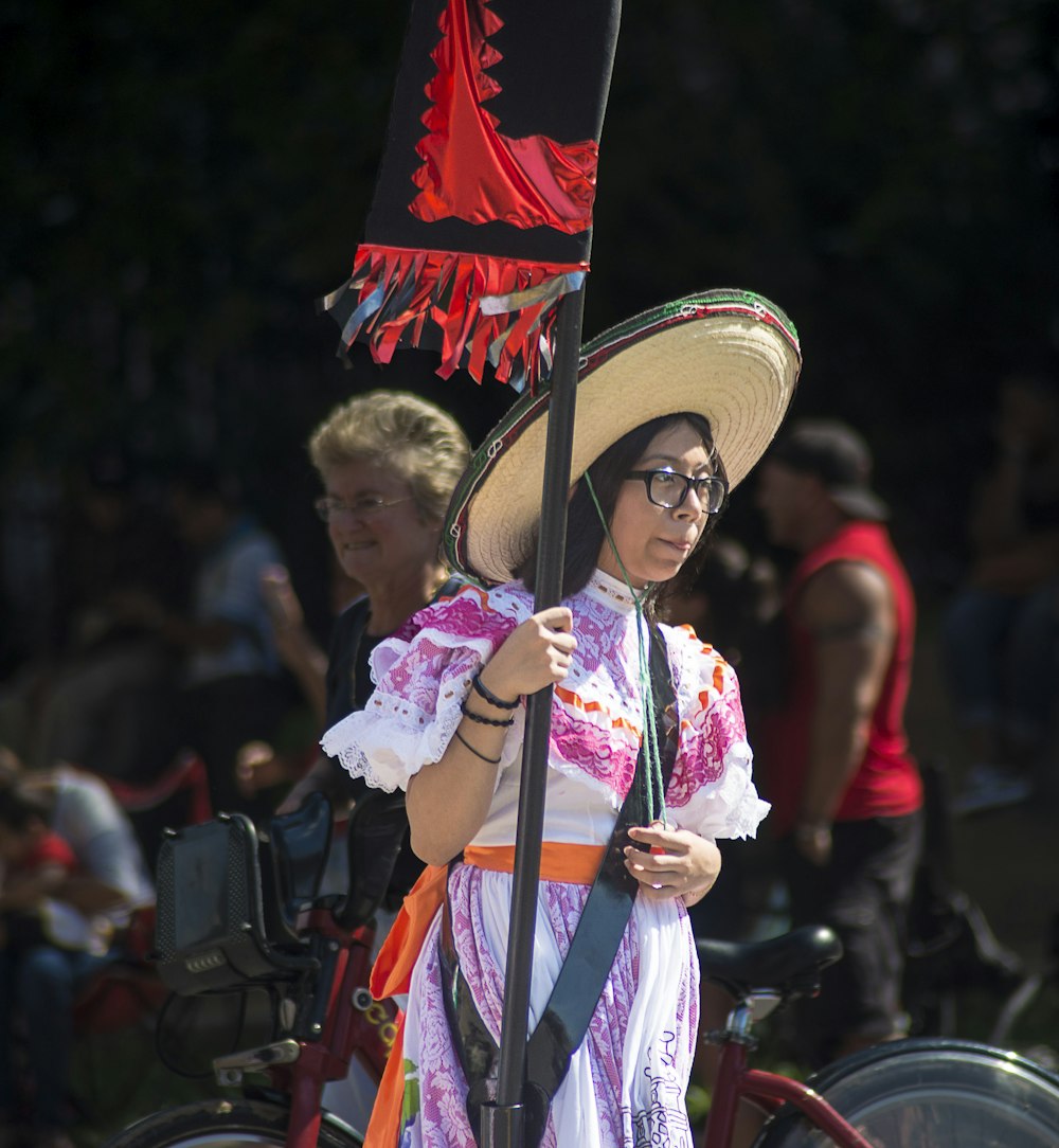 mulher no vestido branco e cor-de-rosa que veste o chapéu branco