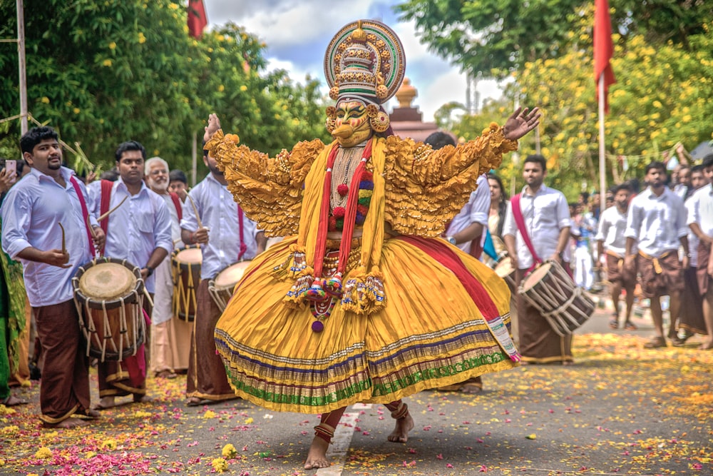 people in gold and red traditional dress walking on street during daytime